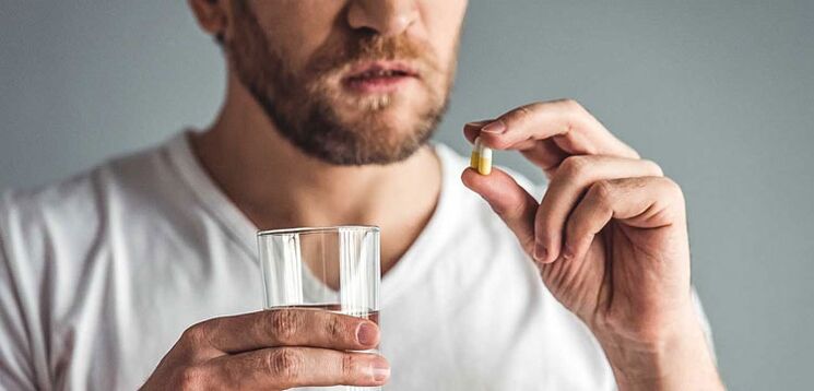 Um homem toma medicamentos para tratar a prostatite